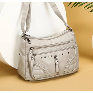 Soft faux leather crossbody bag with multiple zipper pockets and rivet details