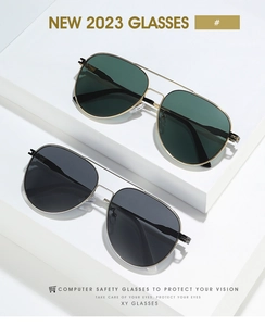 Close-up of classic pilot sunglasses with gold metal double-bridge frames and dark lenses