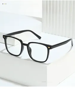 Macro shot of glossy black eyeglass frames showing gold metal hinge and textured details