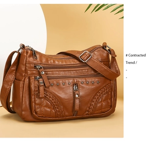 Detail of brown soft leather crossbody bag with multi-layer zippers and woven textures