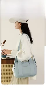 Light blue canvas tote bag showing large capacity and adjustable shoulder strap on model