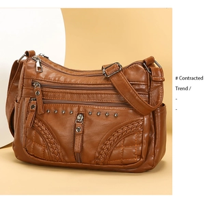 Close-up of soft leather textures and woven stitching details on brown crossbody bag