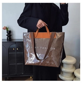 Détail du cabas transparent en PVC avec doublure en papier marron et imprimé mode