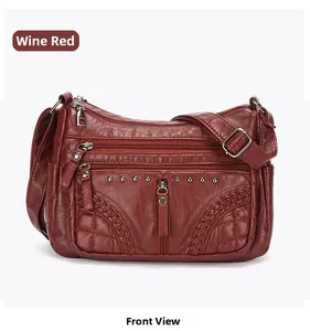 Detail view of wine red PU leather crossbody bag featuring multiple zippers and side weaving