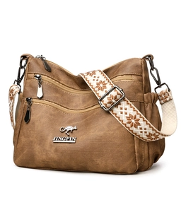 Detail of brown textured tote bag with kangaroo logo and decorative woven shoulder strap