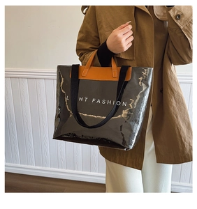 Détail d'un grand sac fourre-tout noir brillant avec garniture marron et lettrage blanc mode