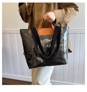 Détail du sac cabas en PVC gris avec imprimé montagne et finitions en cuir marron