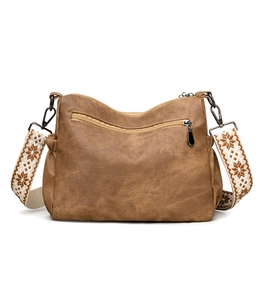 Close-up of brown textured tote bag featuring geometric patterned wide shoulder strap