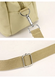 Detail of silver metal hooks and adjustable buckle on a khaki canvas organizer bag