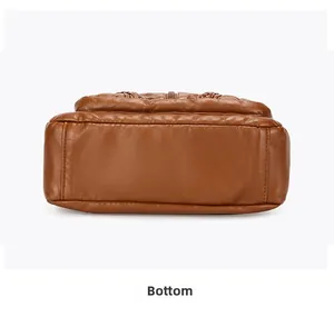 Detailed bottom view of brown leather crossbody bag showing wide flat base and stitching
