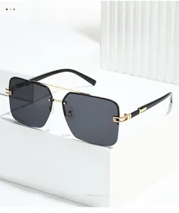 Detail of rimless square sunglasses with gold double bridge and gray lenses on white pedestals