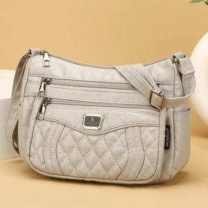 Quilted beige crossbody bag with multi-zipper compartments and adjustable shoulder strap