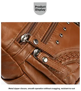 Detail of brown PU leather bag with lychee texture and smooth metal zipper closure