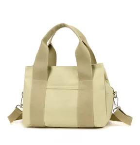 Detail of beige canvas tool bag with detachable shoulder strap and metal hooks