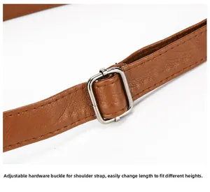 Detail of adjustable brown leather shoulder strap with polished silver metal buckle