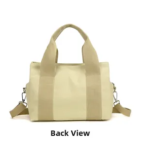 Back view of a premium cream canvas tote bag showing handles and detachable shoulder strap