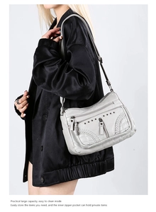Close-up of soft faux leather crossbody bag showing multiple zippers and woven texture