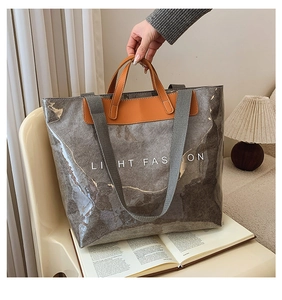 Détail du sac cabas en PVC imperméable avec texture papier brun et anses orange vif