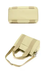 Detailed view of reinforced bottom and side pocket of beige canvas tool tote bag