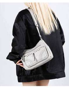 Close-up of soft PU leather crossbody bag with woven texture and metallic stud details