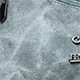 Close-up of silver metal letter hardware detail on large soft leather tote bag