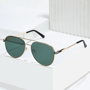 Classic aviator sunglasses with gold metal frame and dark green lenses on white stand