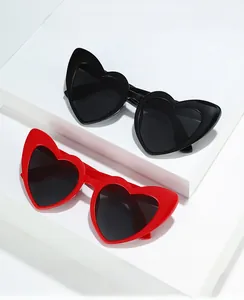 Macro shot of stylish heart-shaped sunglasses in glossy black and red frames