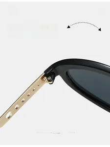 Detail of durable gold metal hinge with circular cutout pattern on black cat-eye sunglasses