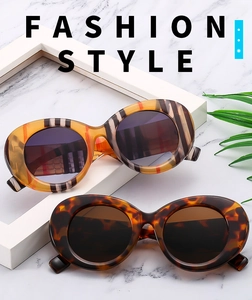 Macro detail of oval sunglasses in iconic plaid pattern and classic tortoise shell texture