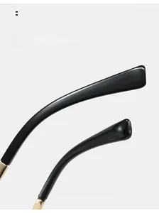 Detailed close-up of sleek black curved sunglasses legs with premium gold metal hinges