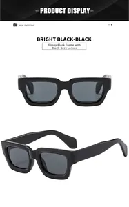 Detail view of glossy black chunky square sunglasses with dark grey tinted lenses