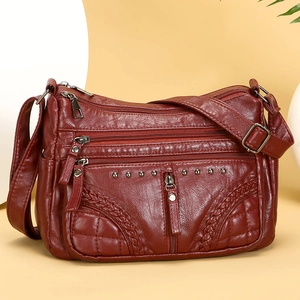 Deep red leather multi-pocket crossbody bag with elegant weave and rivet details