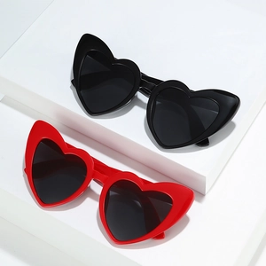 Chic heart shaped cat eye sunglasses in black and red on geometric display stands