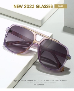 Detail view of purple gradient aviator frames with gold metal accents on tiered blocks