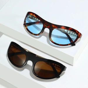 Cat eye sunglasses with hollow metal circles and tortoiseshell frames on white blocks