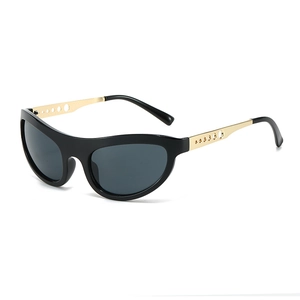 Cat eye sunglasses with black frame and golden hollowed-out metal temples on white background