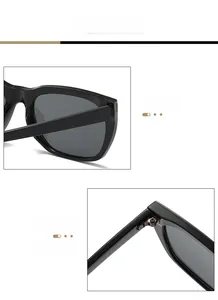 Close-up of black square sunglasses featuring reinforced metal hinges and dark lenses