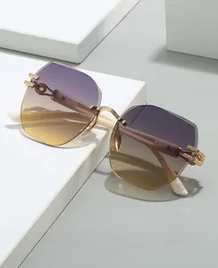 Detail of rimless irregular sunglasses with purple-yellow gradient lenses and gold frames