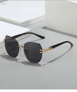 Detail view of rimless oversized sunglasses with geometric grey lenses and gold metal hinge