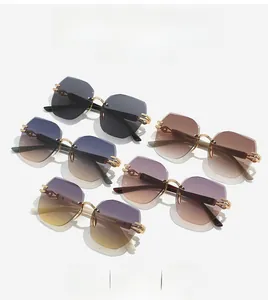Detail view of rimless geometric sunglasses with gradient lenses and carved gold metal temples