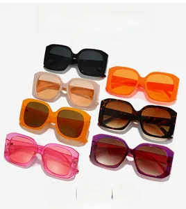 Flat lay display of oversized square sunglasses in various vibrant colors on white background