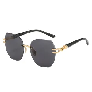Frameless oversized octagonal sunglasses with gray lenses and gold engraved metal temples
