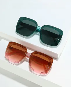 Lunettes de soleil carrées pailletées vert foncé et dégradé orange rose sur support blanc