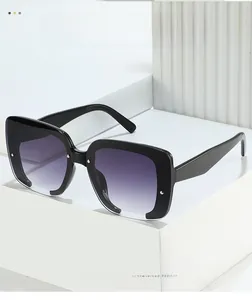 Gros plan de lunettes de soleil carrées surdimensionnées avec monture noire et verres dégradés
