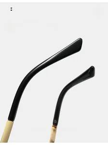 Detail view of curved mirror legs in black resin and gold metal for pilot sunglasses