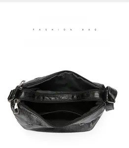 Detail view of large capacity black leather crossbody bag with multiple zip compartments