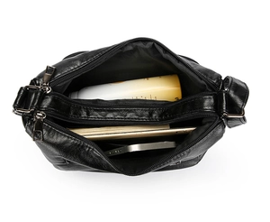 Top view of large capacity black PU leather shoulder bag showing multiple zipper compartments