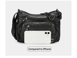 Detailed comparison of black multi-zipper crossbody bag size with an iPhone