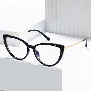 Lunettes œil-de-chat chics avec monture noire en TR90 et branches dorées sur un socle blanc
