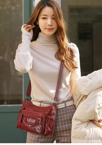 Detail of soft wine red crossbody bag with multiple zippers and woven texture details